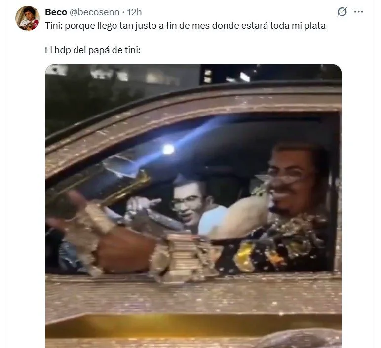 Un hombre sonríe con anteojos y joyas junto a otro dentro de un auto dorado cubierto de brillos.