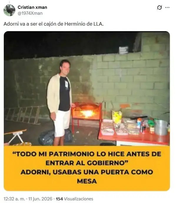Manuel Adorni parado al lado de una parrilla prendida y una mesa con comida en un patio.