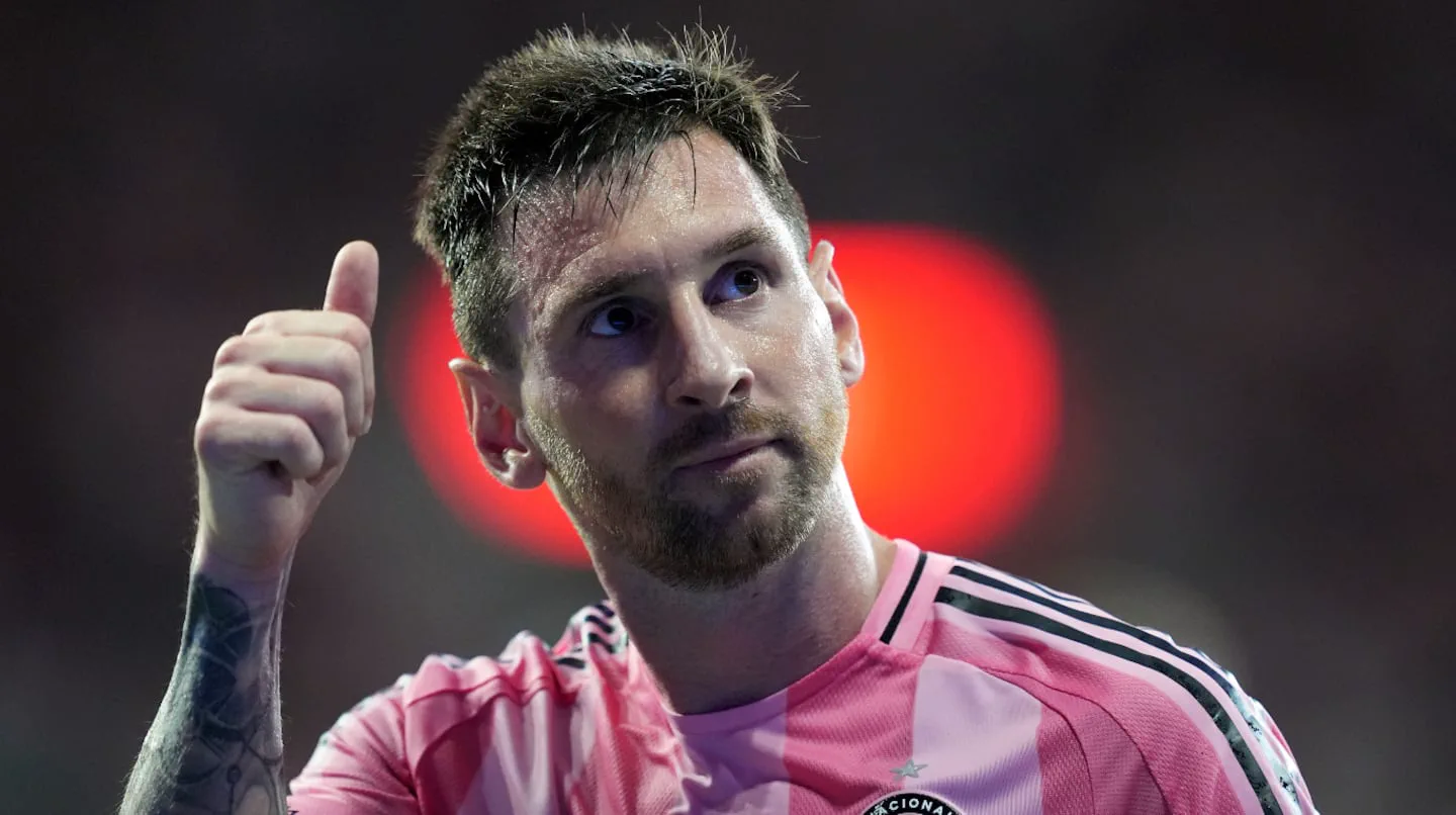 Lionel Messi con la camiseta rosa del Inter Miami levantando el pulgar en una cancha de fútbol.