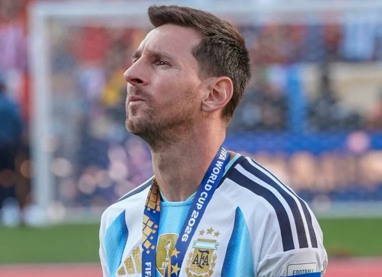 Lionel Messi mira hacia arriba con la camiseta de la selección argentina y una medalla colgada al cuello.