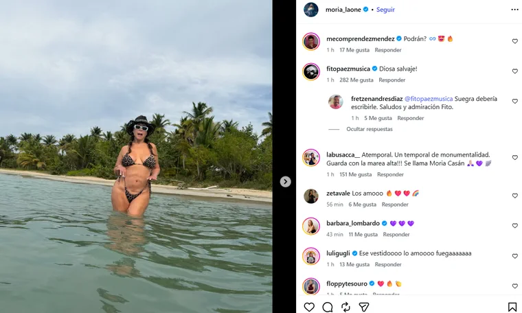 Moria Casán posa con sombrero y bikini con estampado animal dentro del agua en una playa.