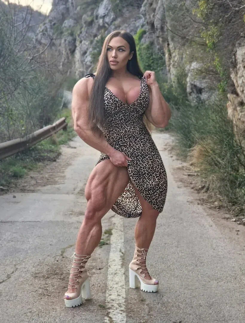 Nataliya Kuznetsova parada en un camino de asfalto con vestido de leopardo y tacos altos.