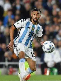 Nicolas Gonzalez con la camiseta de la seleccion argentina de futbol conduciendo una pelota en la cancha.