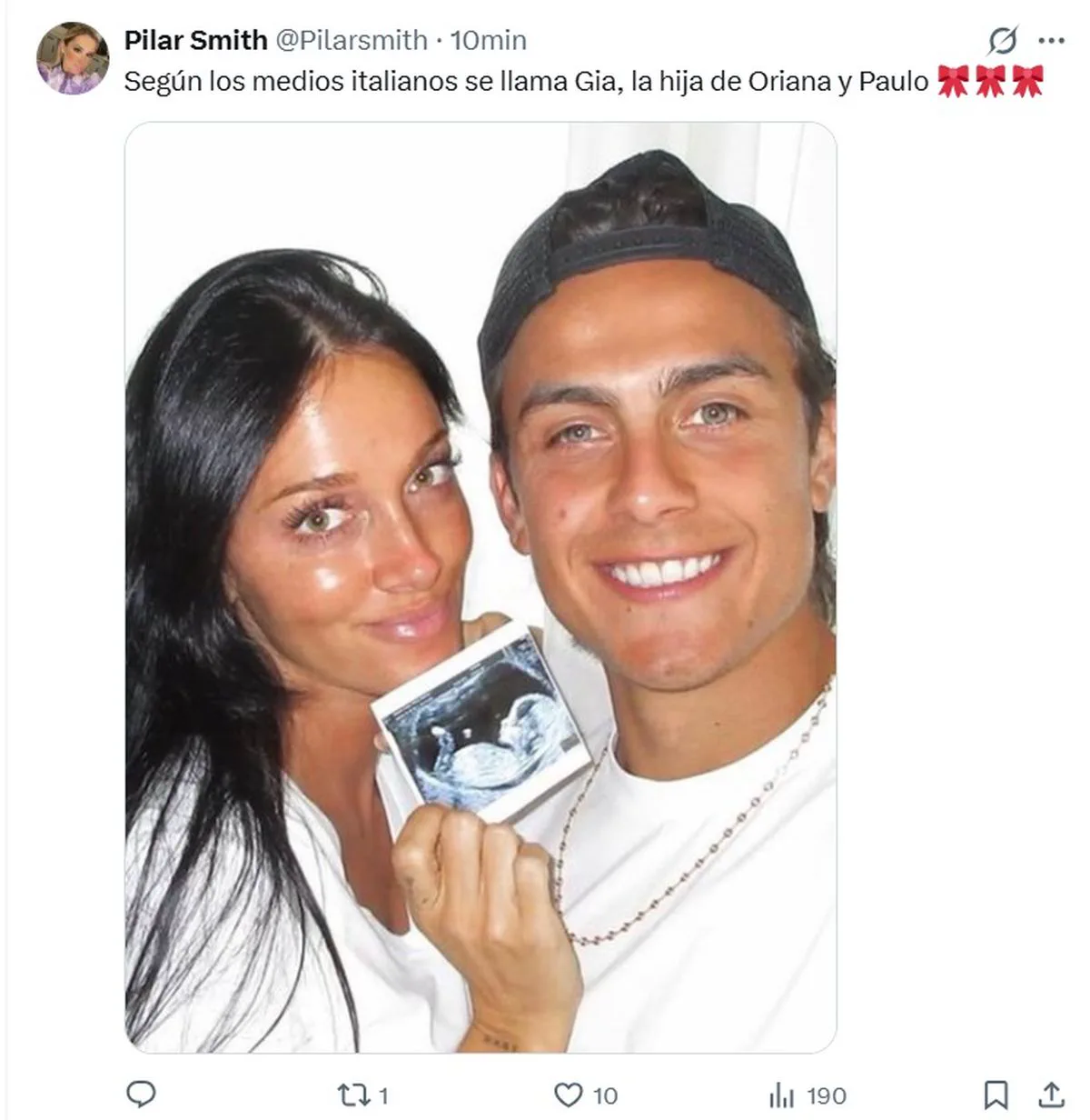 Oriana Sabatini y Paulo Dybala posan sonriendo mientras sostienen la imagen de una ecografía.