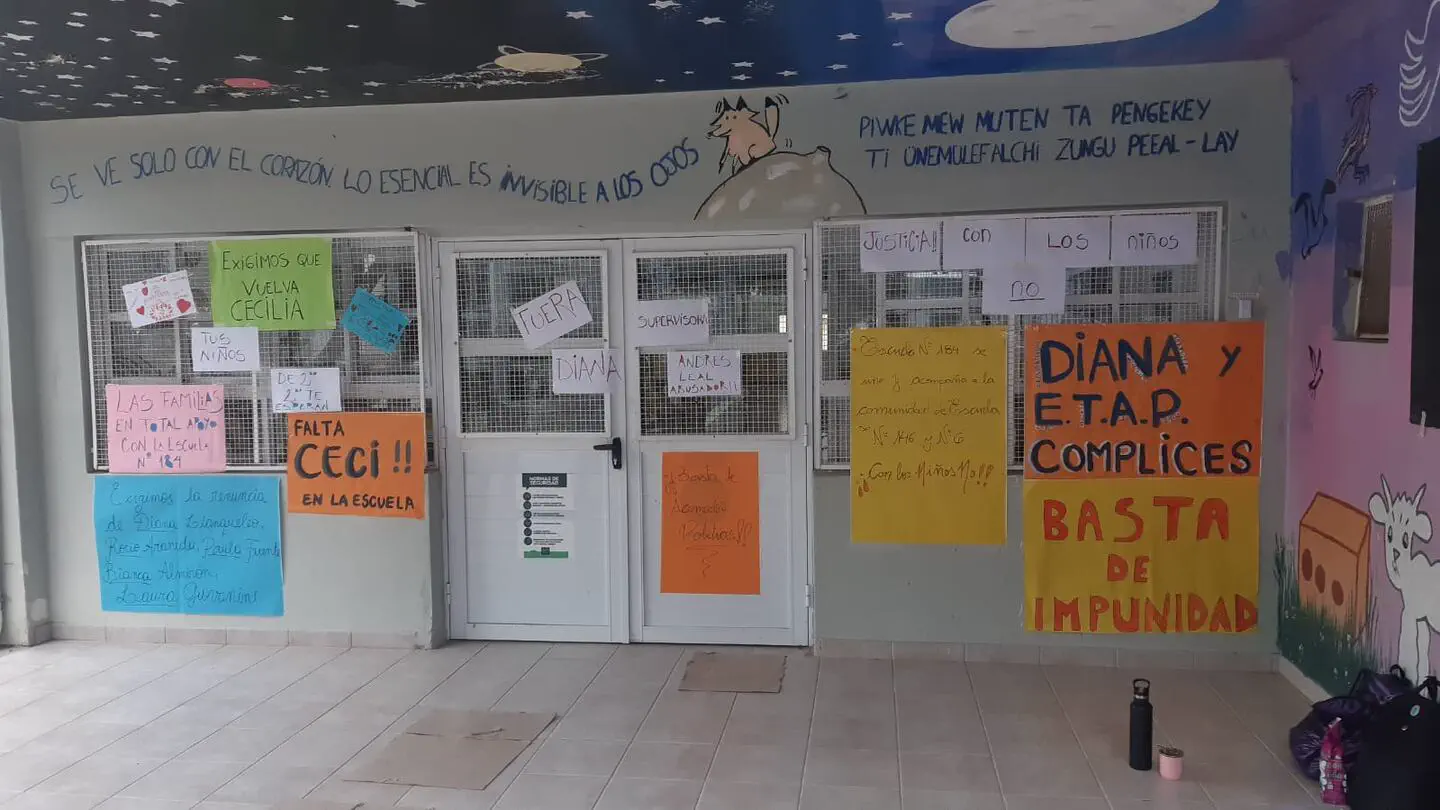 Carteles de protesta pegados en las puertas y ventanas de una escuela.