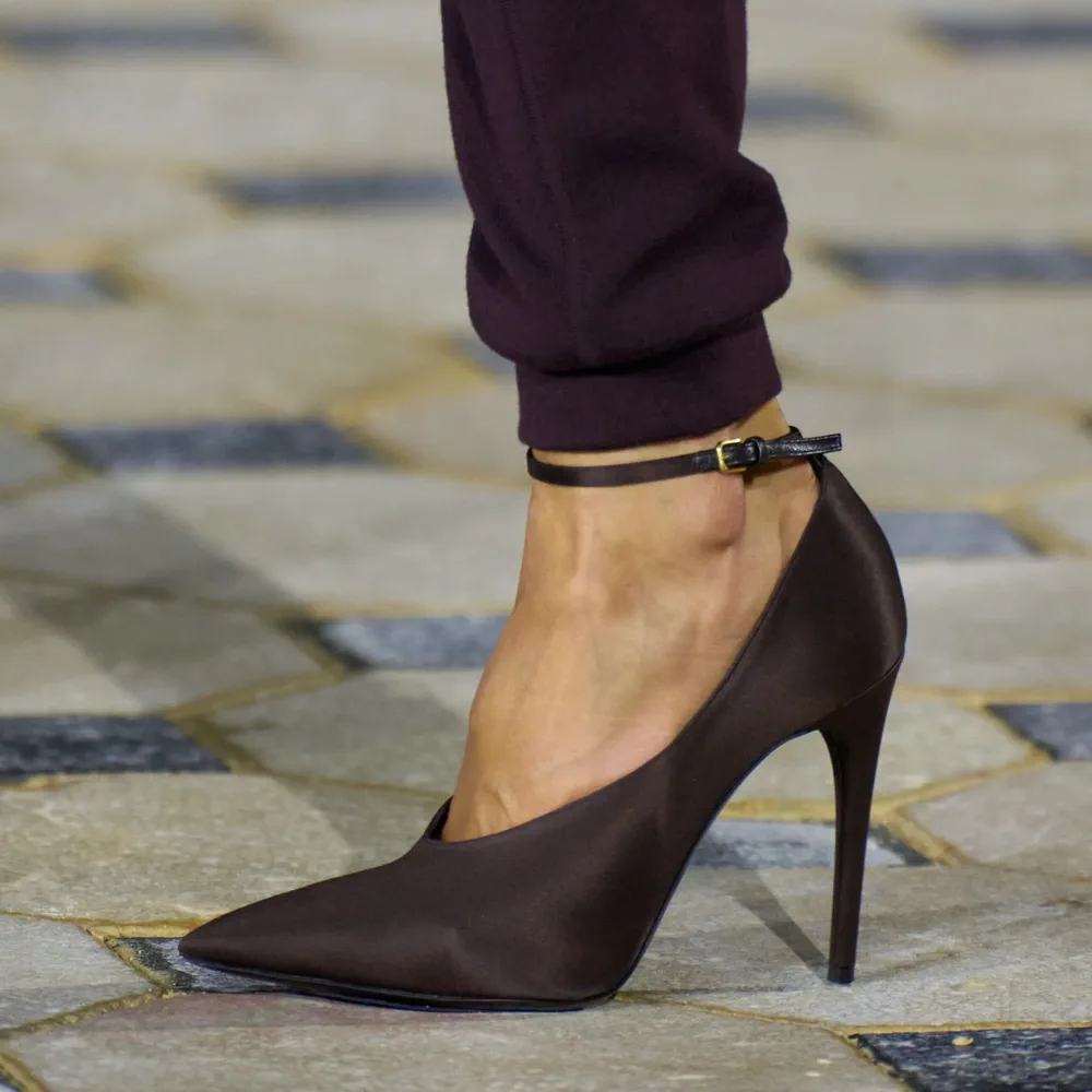 Un pie calza un zapato de taco aguja color bordó oscuro con pulsera fina al tobillo.