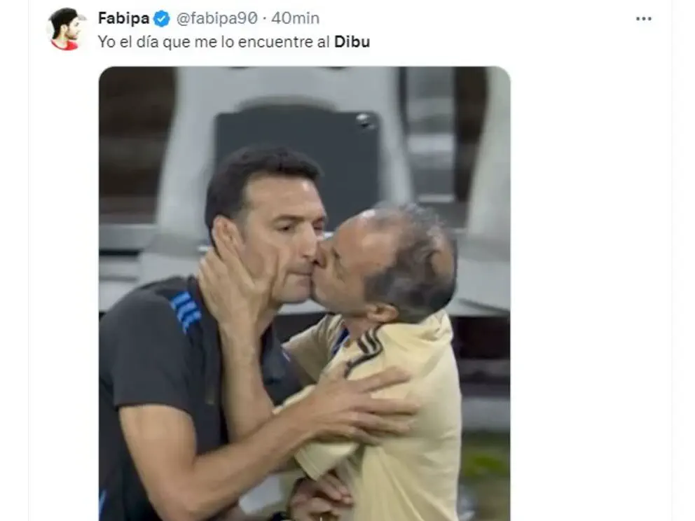 Un hombre besa en la mejilla a Lionel Scaloni mientras lo sostiene de la cara.