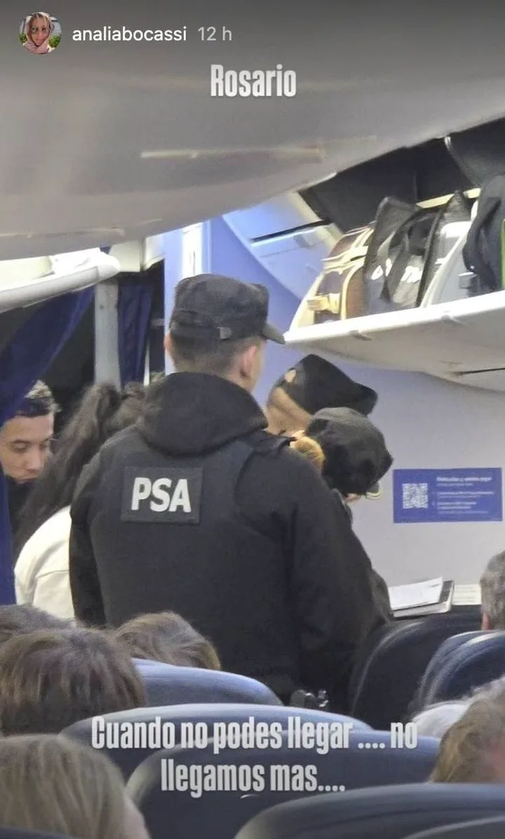 Efectivo de la PSA de espaldas en el pasillo de la cabina de pasajeros de un avión.