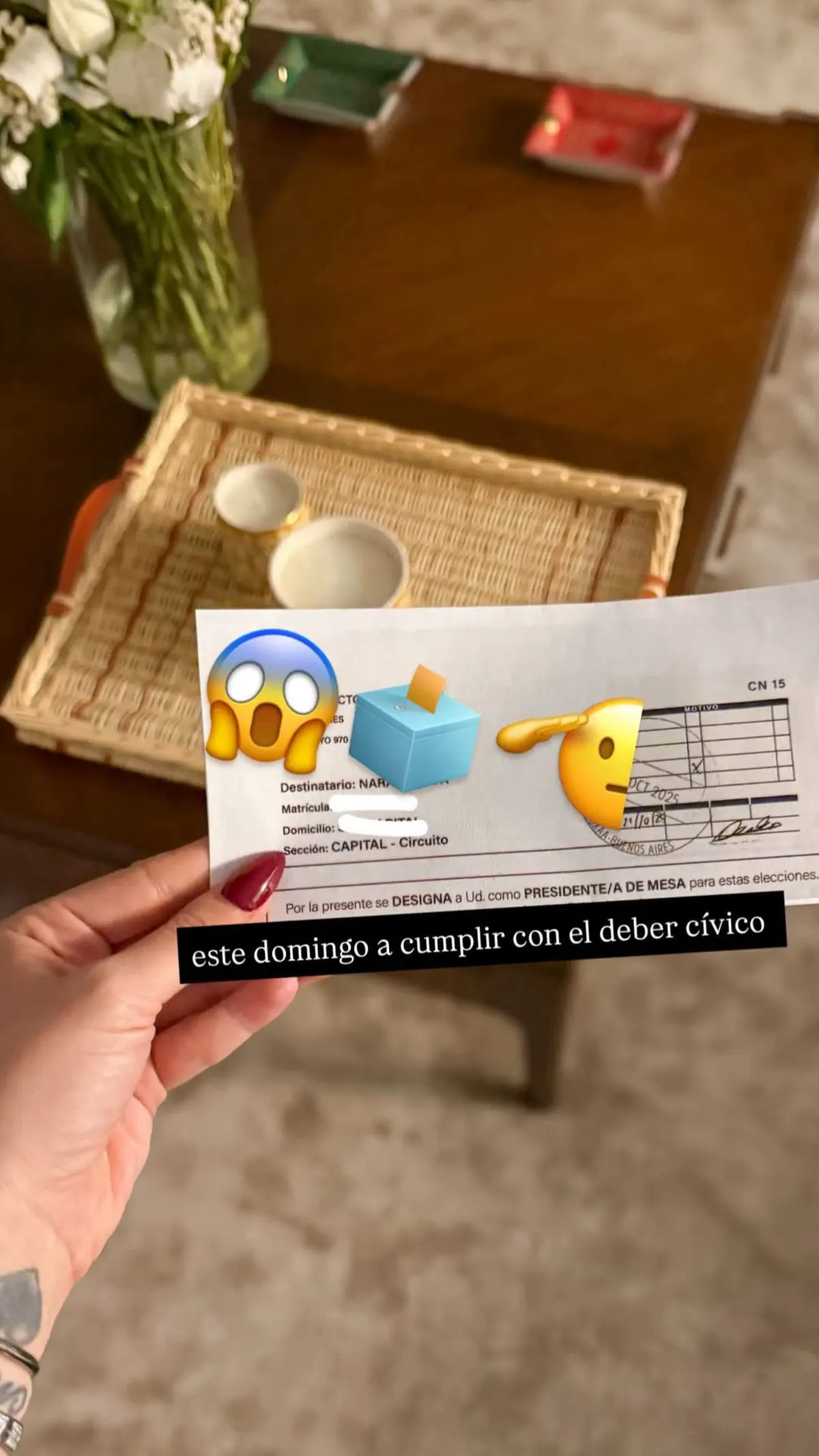 Una mano sosteniendo una notificación de designación como presidente de mesa electoral.