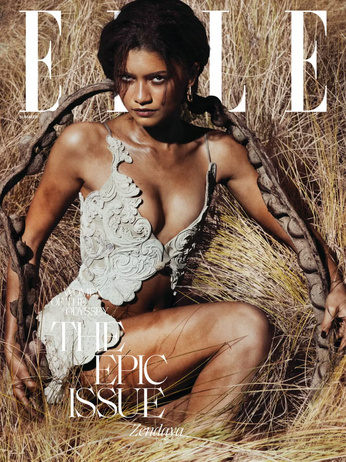 Zendaya aparece en la portada de la revista Elle con un top blanco calado entre pastizales secos.