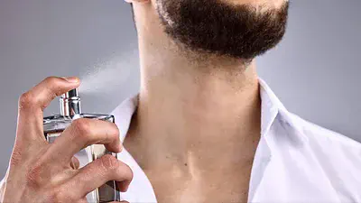 hombre colocándose perfume